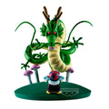 A Dragon Ball figure set on a white background, featuring a large green and yellow dragon with red eyes, pink and purple mushrooms, and a small character in front of a round green base. The Banpresto logo is visible on the base.