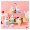 Colorful ice cream cone-shaped figurines with cartoon faces on a pink background