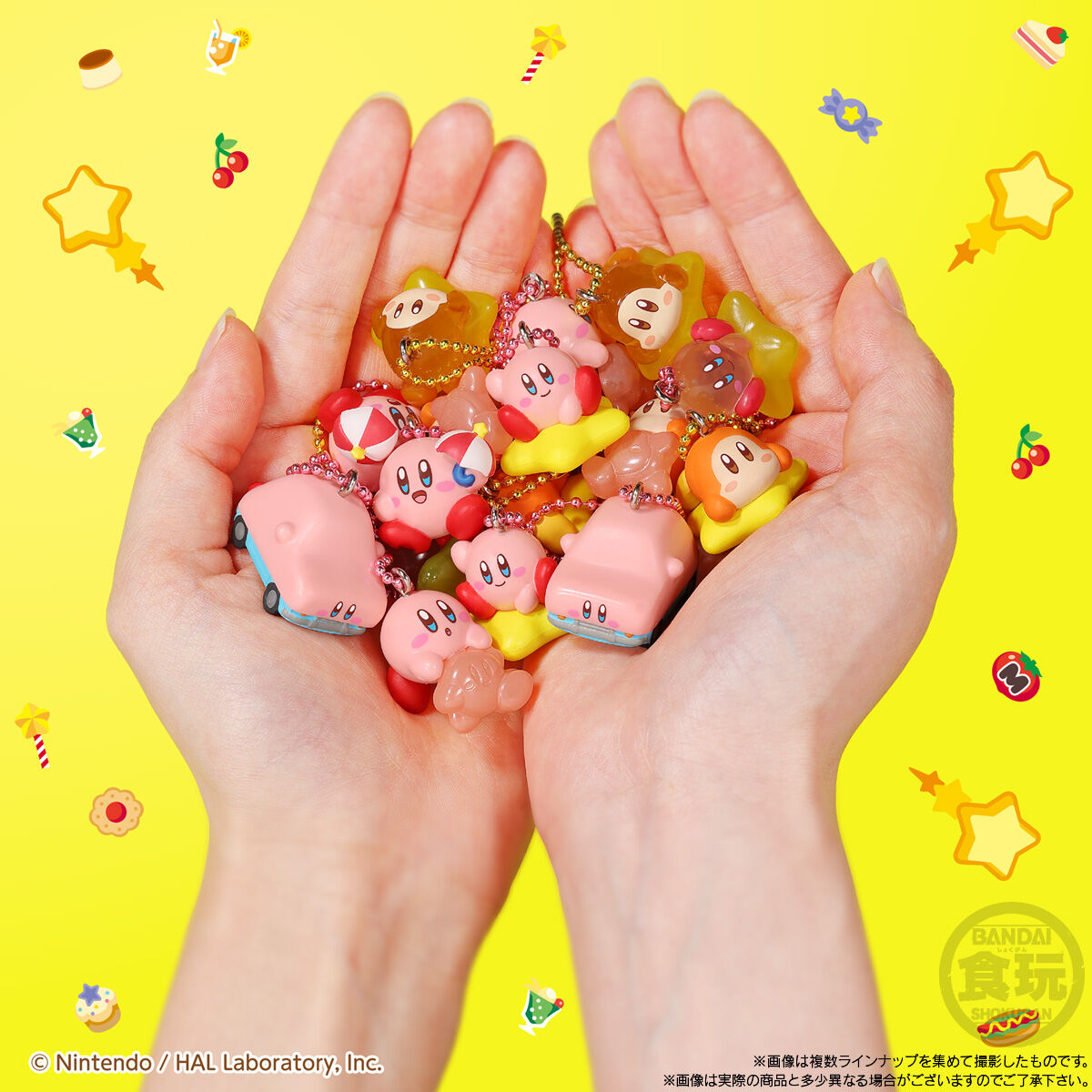 Hands holding small character figurines against a yellow background with cartoonish decorations.