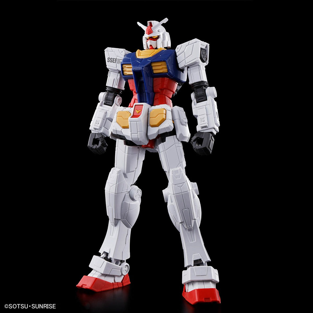 Model kit of a robot with white, blue, red, and yellow colors on a black background.