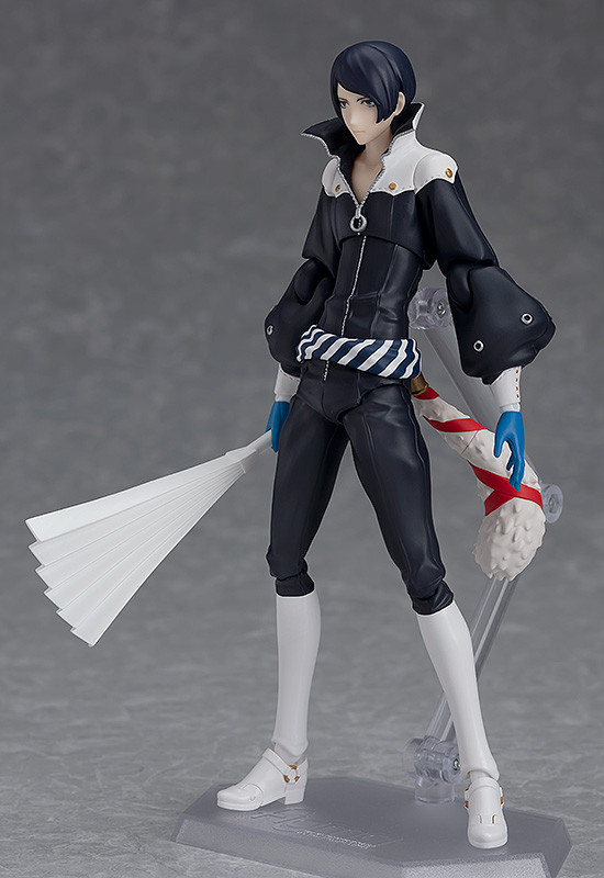 Action figure with dark hair and black outfit holding a fan and weapon on a gray background