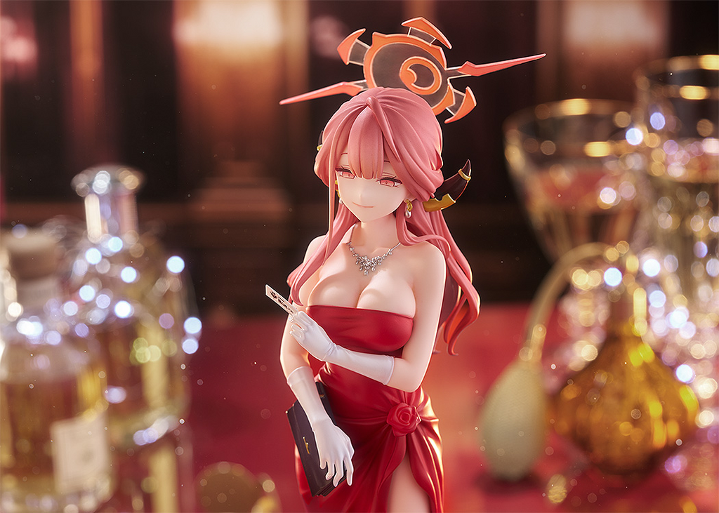 Anime character figurine in a red dress with a blurred background of bottles and glasses.