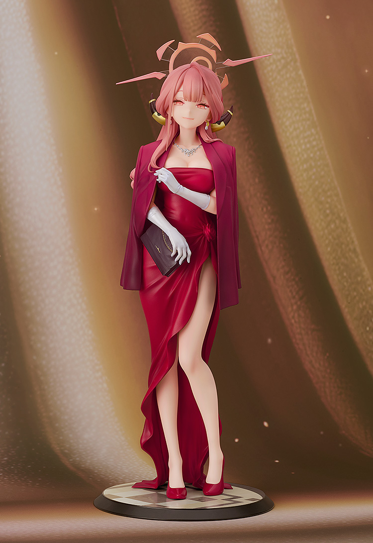 Figurine of a character in a red dress with a pink hair bow against a brown background