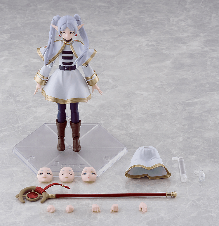 An anime action figure displayed on a clear stand with accessories arranged around it on a light gray marble-like surface. The figure has long pale lavender hair, pointed ears, a white dress with gold trim, dark purple leggings, and brown boots.