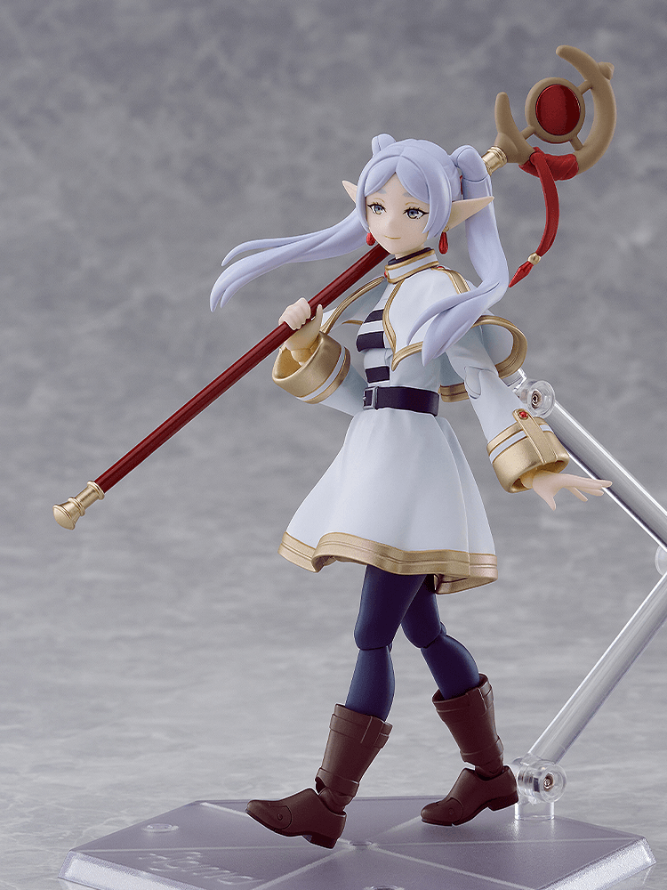 Figurine of an anime character with white hair and a staff on a gray background