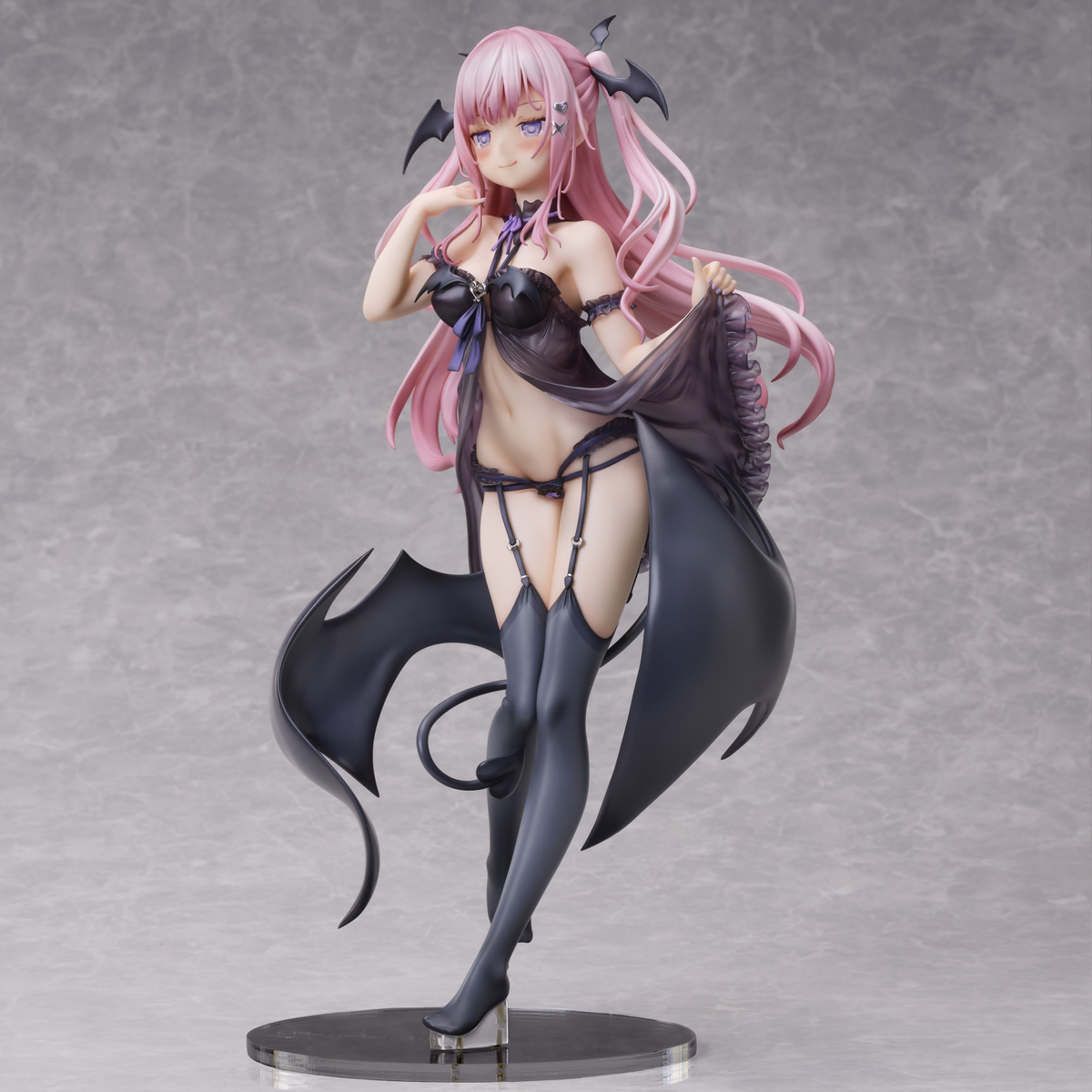 Anime character figurine with pink hair and black outfit on a gray background