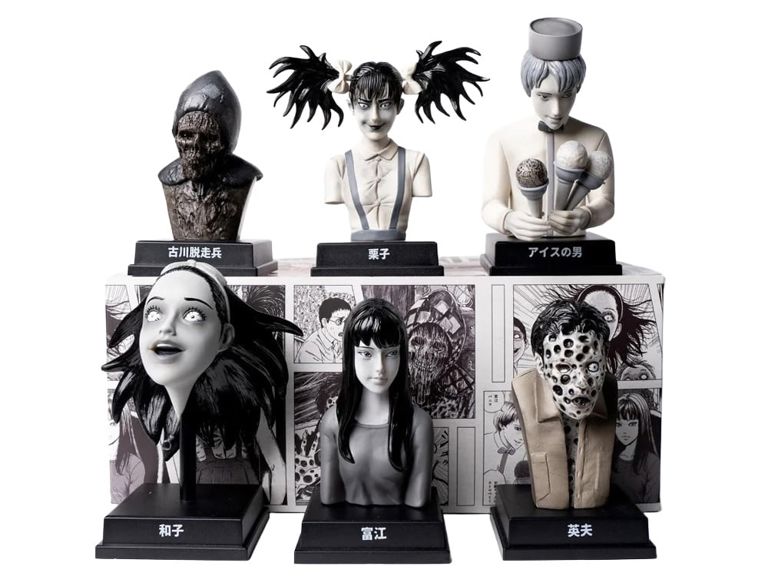 Collection of black and white character busts on a display stand with comic book panels in the background.