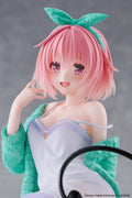Anime character figurine with pink hair and green headband against a gray background