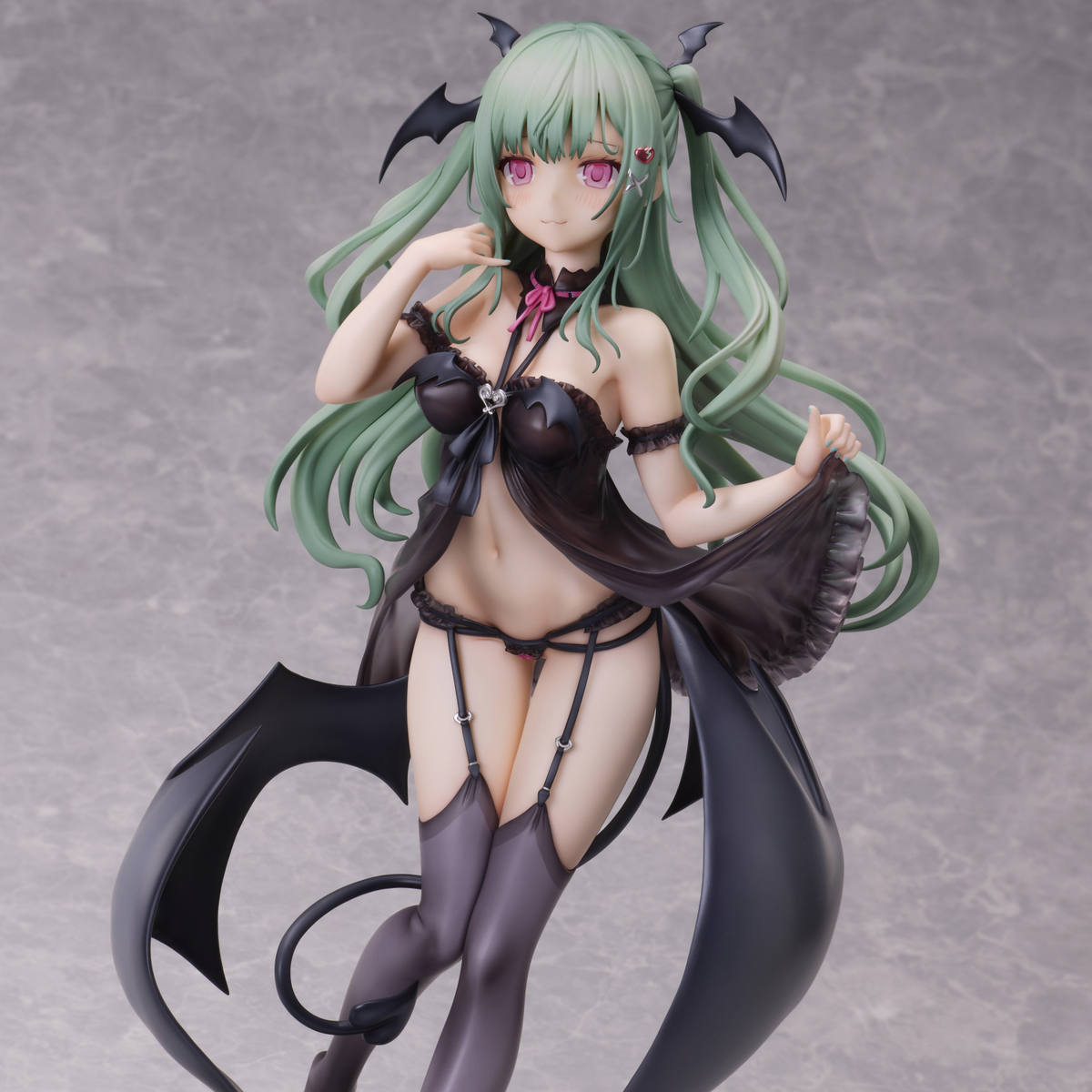 Anime figurine with green hair and black outfit on a gray background