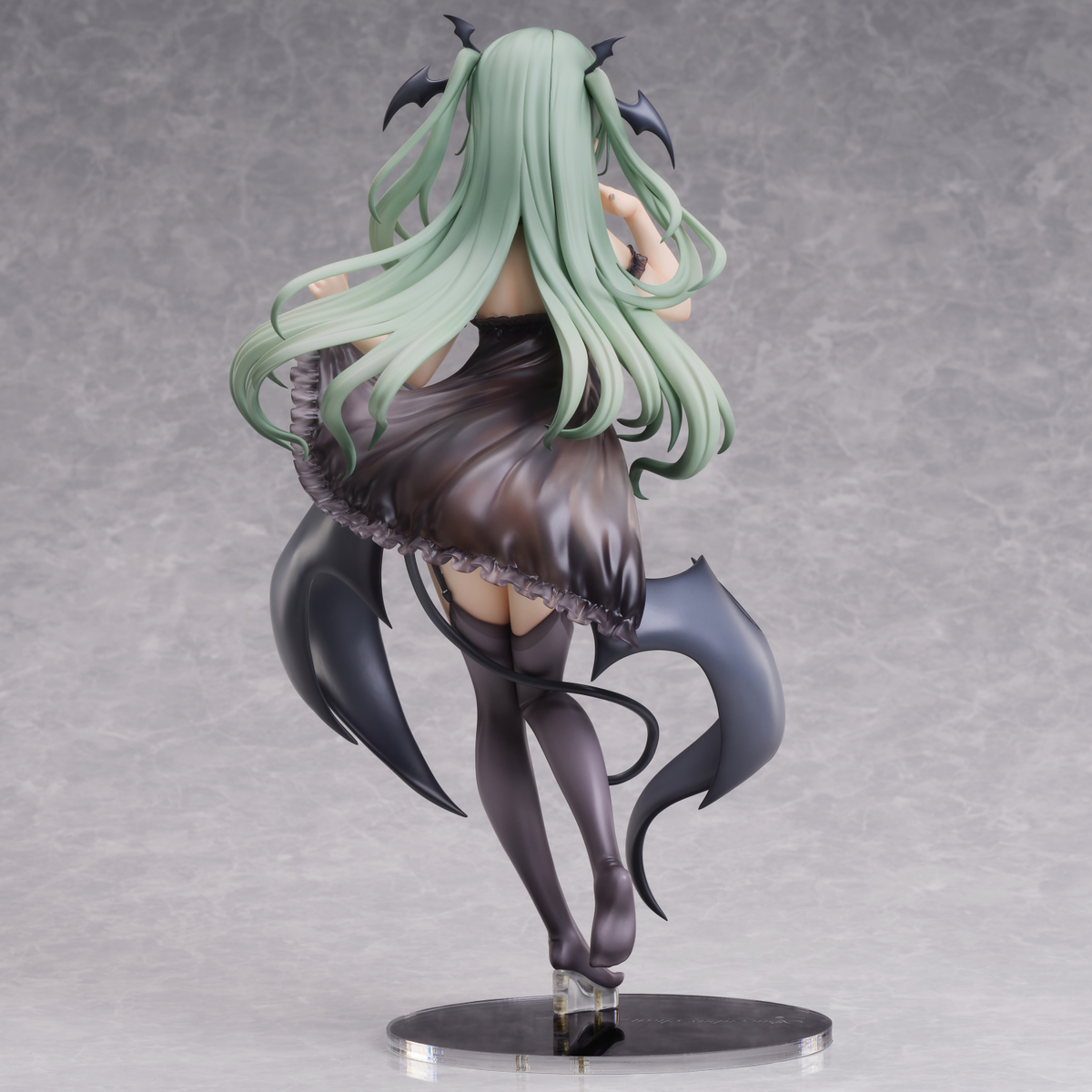 Anime character figurine with green hair and black tail on a gray background
