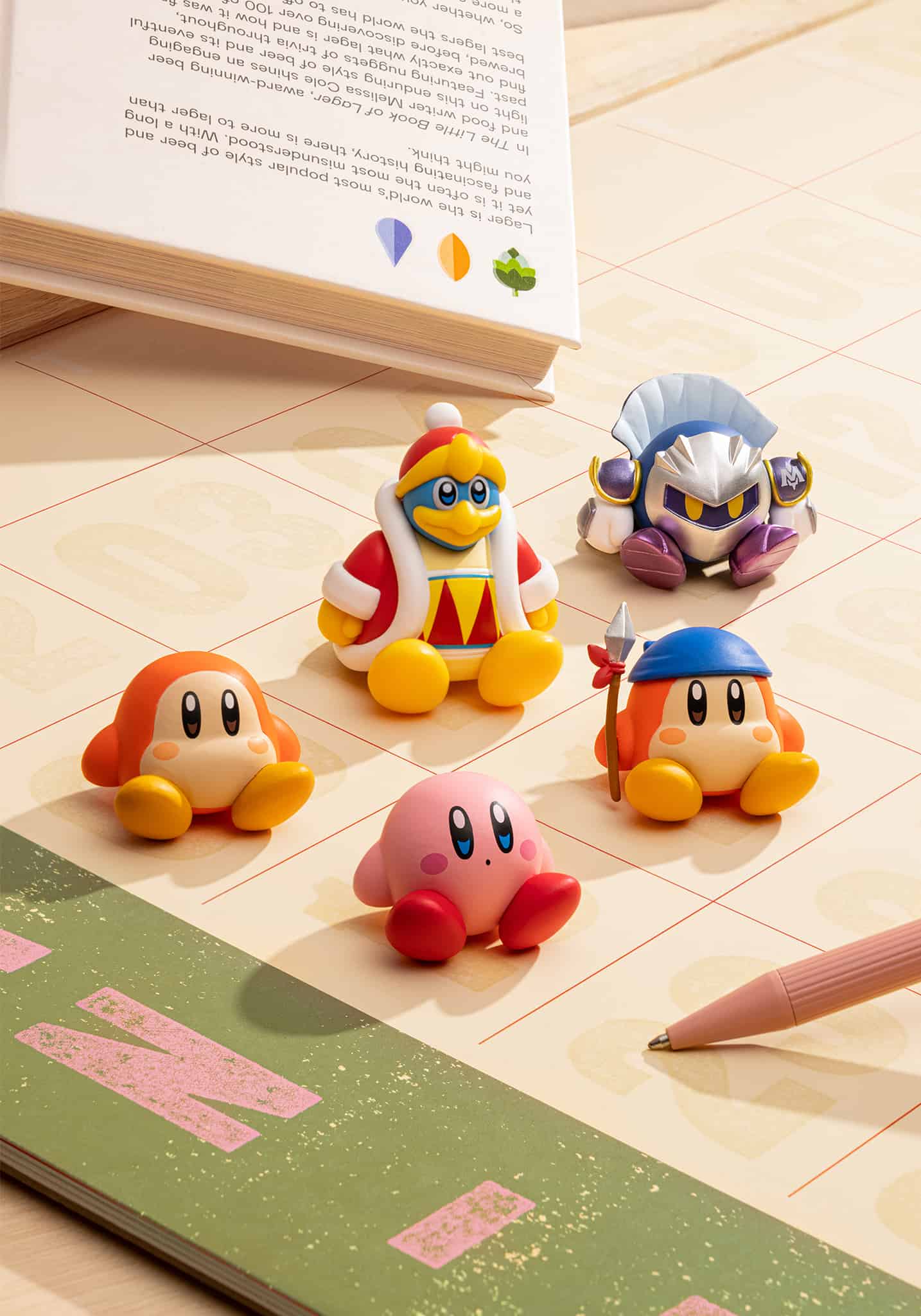Four colorful character figurines on a tiled floor next to an open book.
