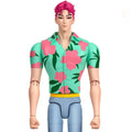 A stylized male action figure or doll with pink hair, wearing a mint green short-sleeve button-up shirt with large pink floral print and dark green leaves, plus light blue pants, shown against a plain white background.