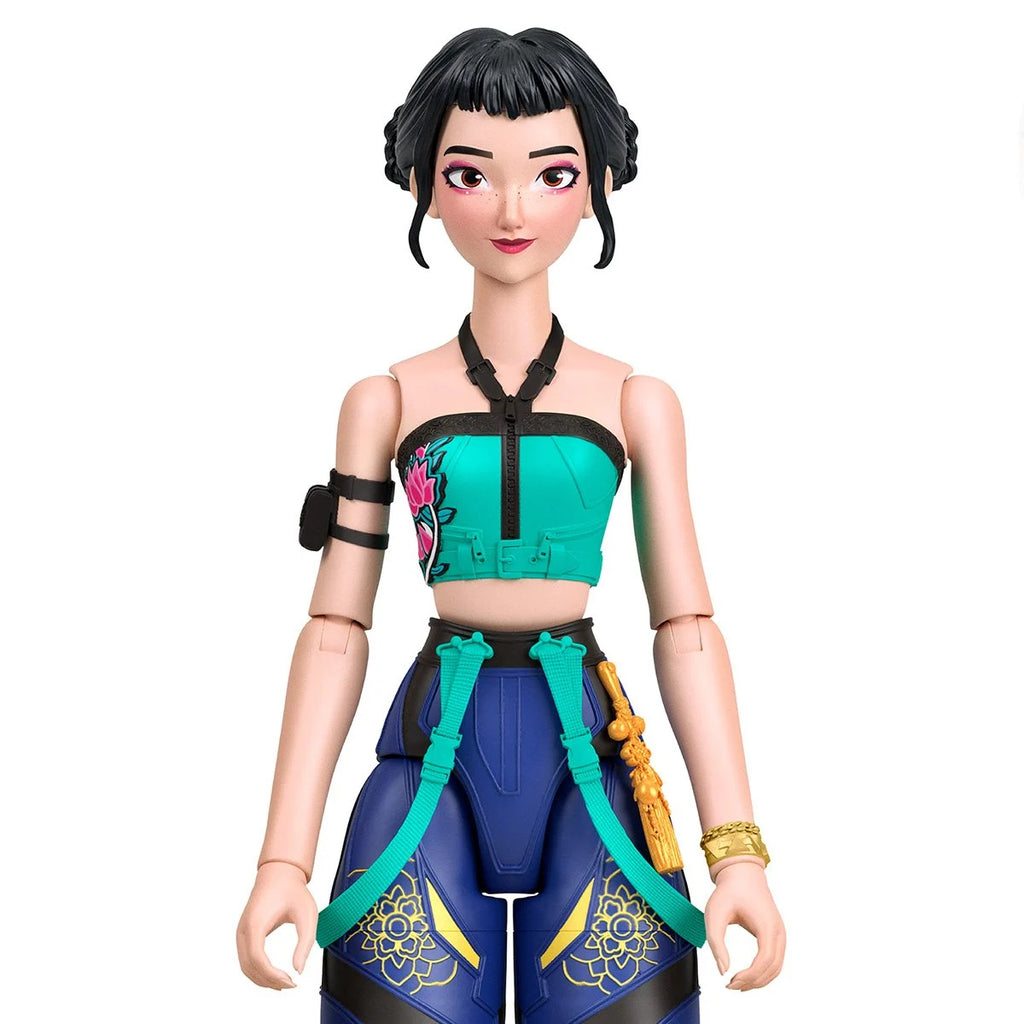 A stylized female action figure or doll shown against a plain white background. The figure has black hair, a turquoise and black cropped top with floral print, blue pants with gold floral details, and teal and black accessories.