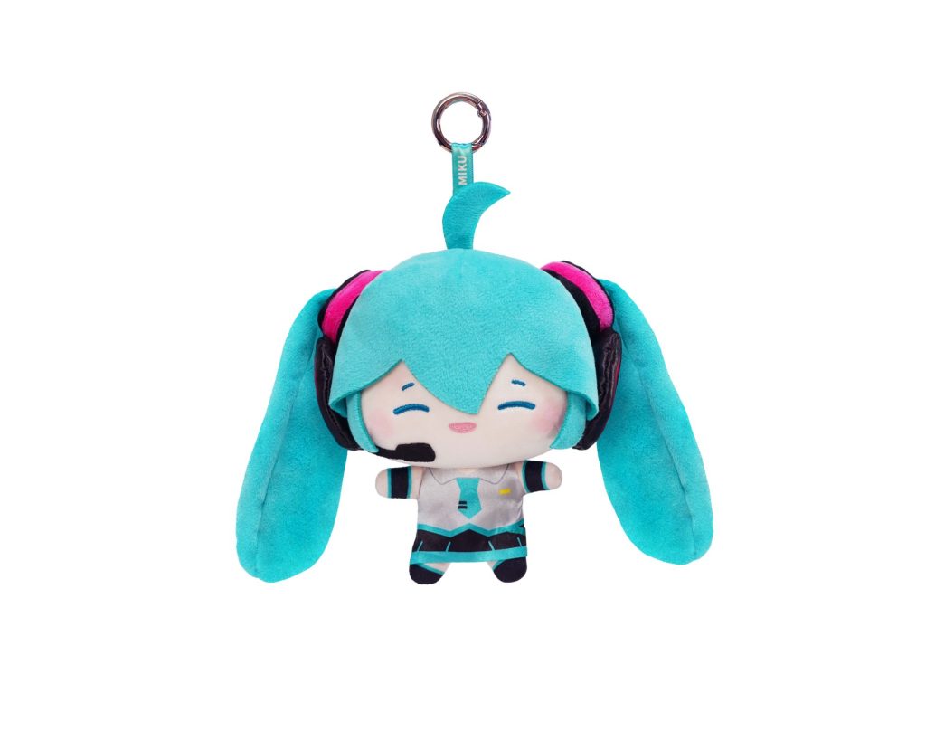 A cute plush keychain of Hatsune Miku in her signature turquoise twin-tail outfit with pink headphones, attached to a silver metal key ring, shown against a plain white background.