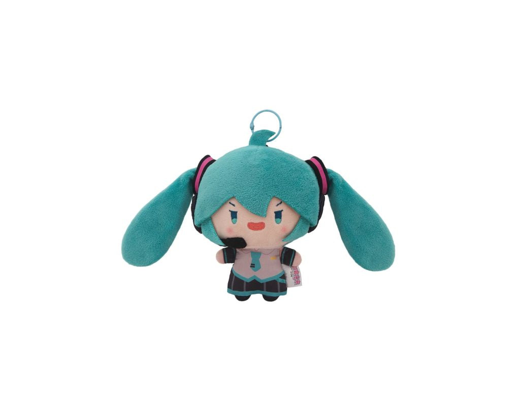 A plush keychain of Hatsune Miku with turquoise hair, a small smiley face, and a metal key ring at the top, shown on a plain white background.