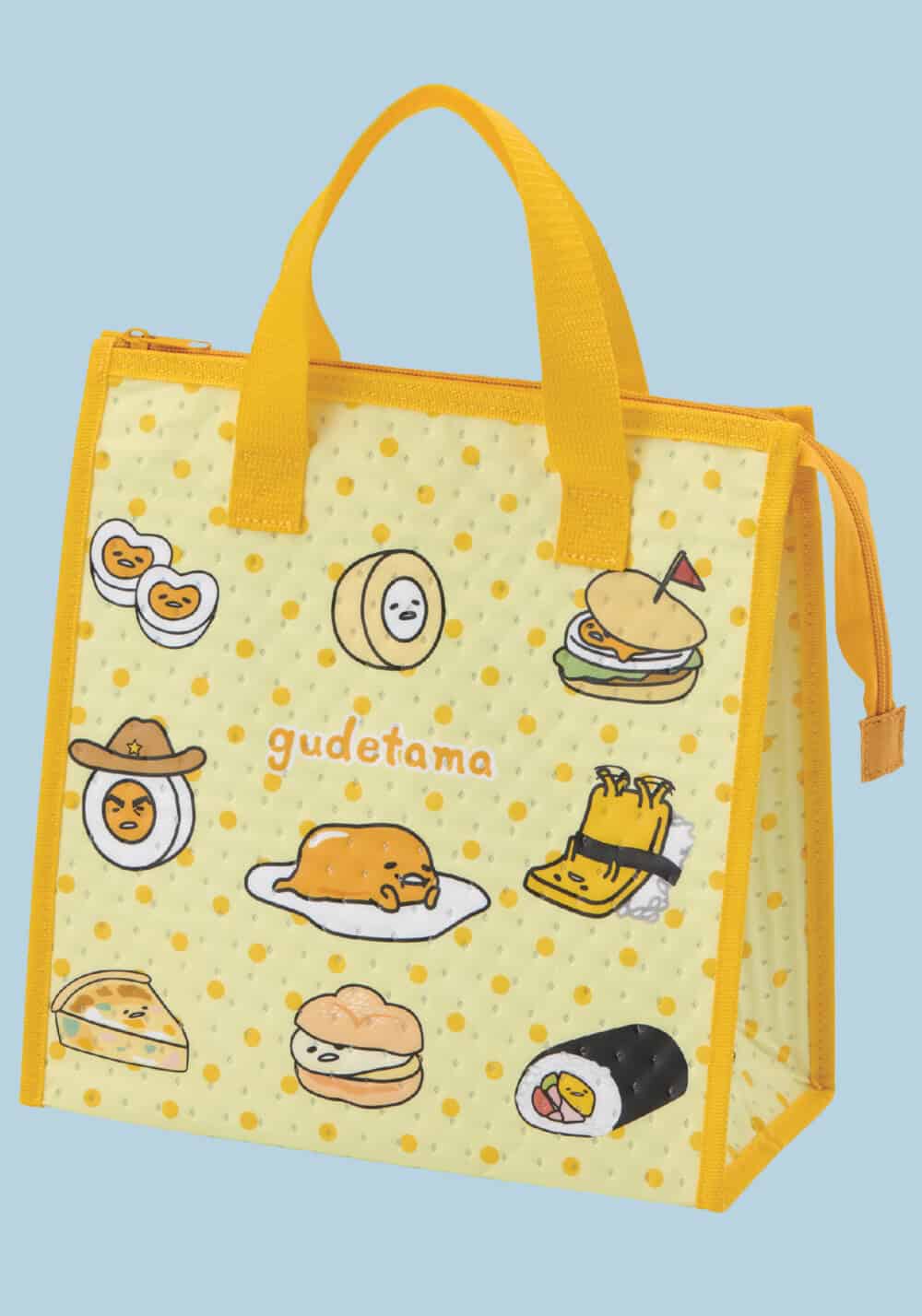 A yellow insulated tote bag with Gudetama illustrations and the Gudetama logo, set against a solid light blue background.