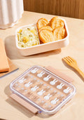 Bento box with compartments containing food on a wooden table
