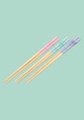 Set of colorful chopsticks on a light green background