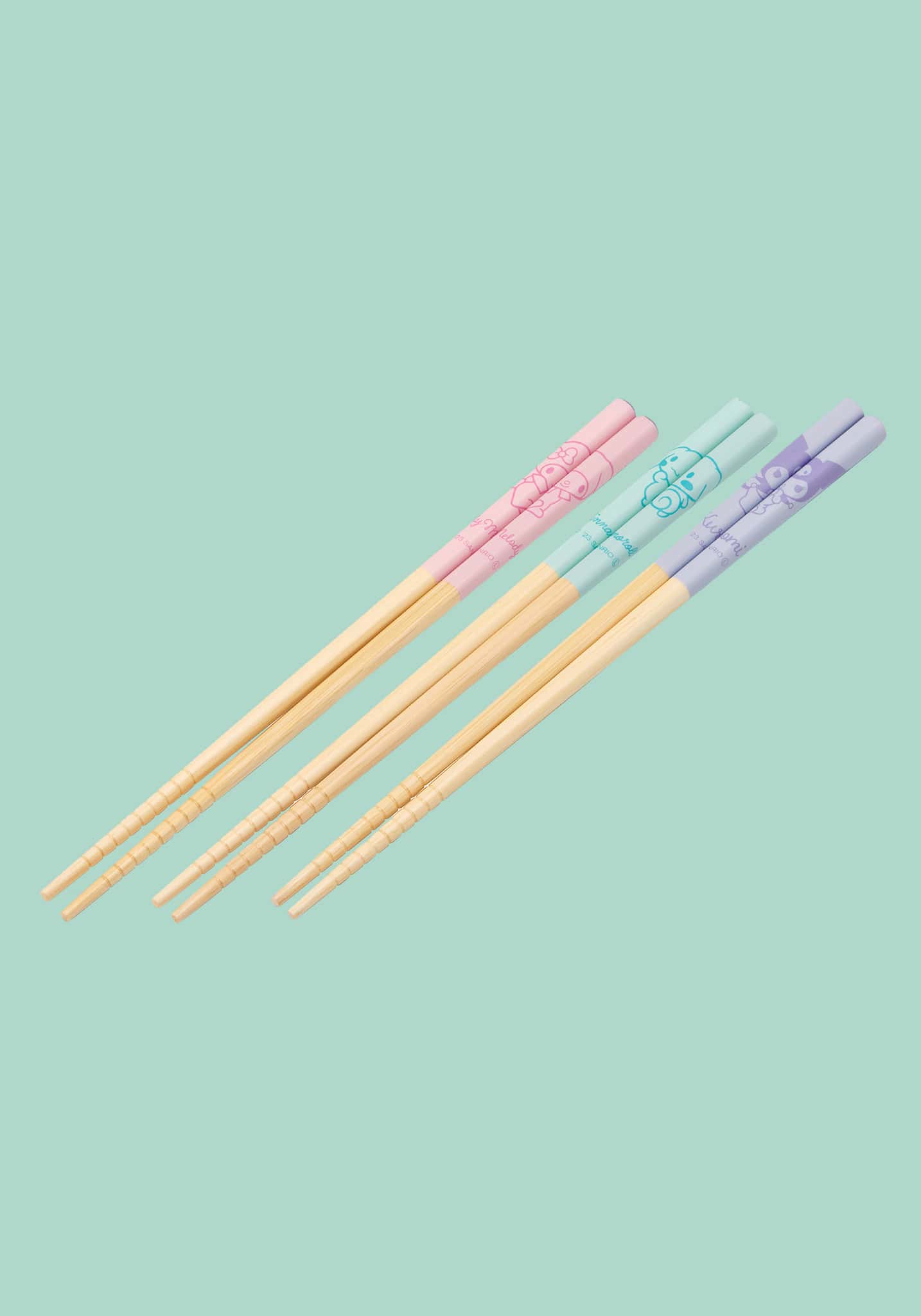 Set of colorful chopsticks on a light green background