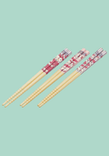 Set of decorative chopsticks with floral patterned ends on a light blue background