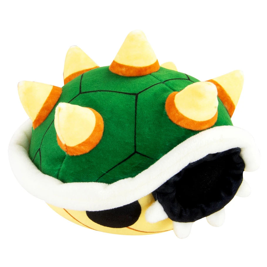 Green turtle-like plush toy with yellow spikes on a white background