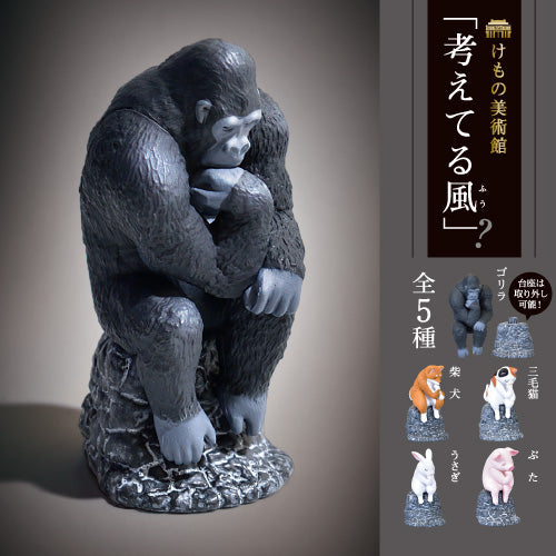 Statue of a gorilla sitting with its hands on its knees against a brown background.
