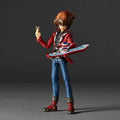 Action figure of a character in a red and blue outfit holding a device against a dark background