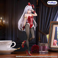 Anime character figurine in a red outfit with bunny ears on a table with a cup and saucer.