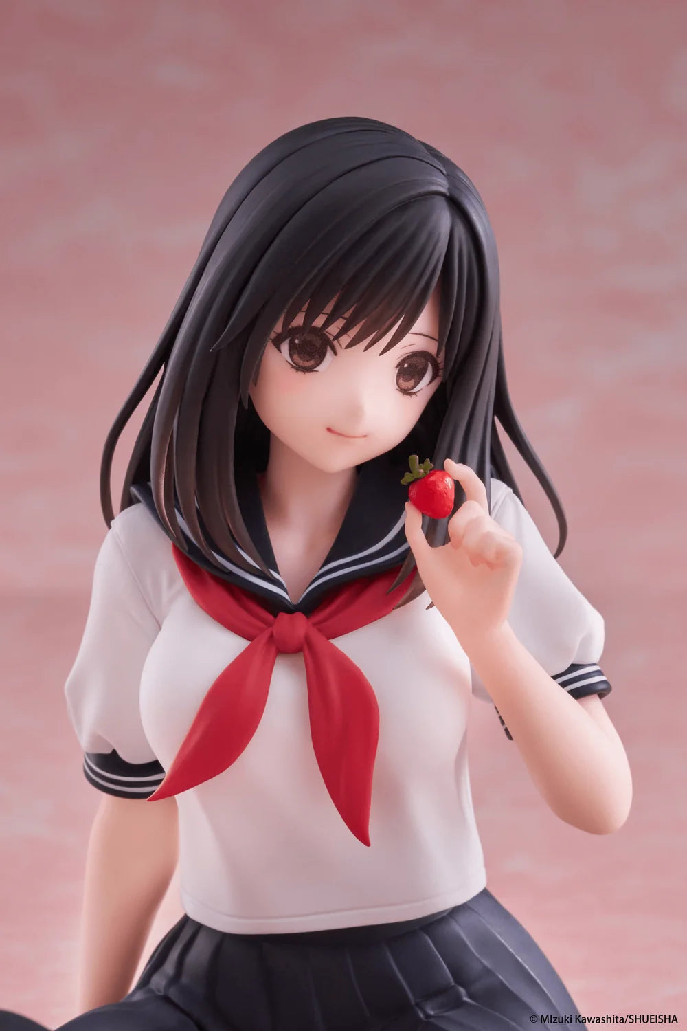 Figure of a girl in a school uniform holding a strawberry against a pink background