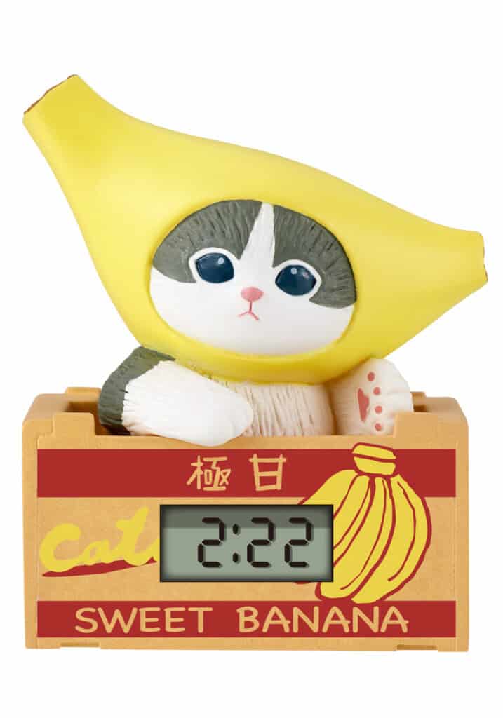 Cat-shaped clock with banana costume in a wooden crate labeled 'Sweet Banana'.