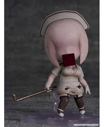 A small stylized collectible figure shown from the back, wearing a pale pink outfit and nurse hat, with a dark red block covering the face and holding a cane, on a dark gray background.