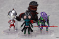 Four collectible action figures displayed on clear plastic stands against a light gray background: Ultraman, a black monster with red accents, a purple and green robot, and a central black figure with large pink eyes and a teal chest panel.
