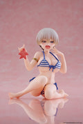 Figurine of a character in a bikini holding a red flower on a pink background