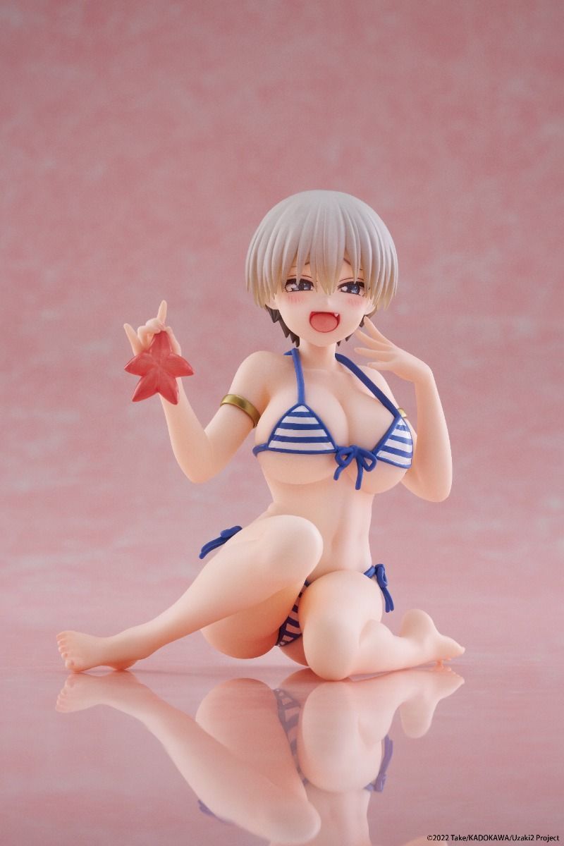 Figurine of a character in a bikini holding a red flower on a pink background