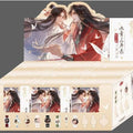 An illustrated product display box featuring two anime-style characters in traditional East Asian clothing, with multiple small product previews along the bottom including watches, keychains, and accessories. The box is cream and beige with red and black artwork, set against a dark gray background.