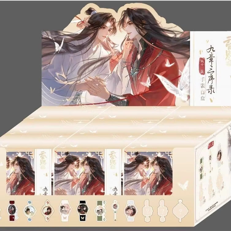 An illustrated product display box featuring two anime-style characters in traditional East Asian clothing, with multiple small product previews along the bottom including watches, keychains, and accessories. The box is cream and beige with red and black artwork, set against a dark gray background.