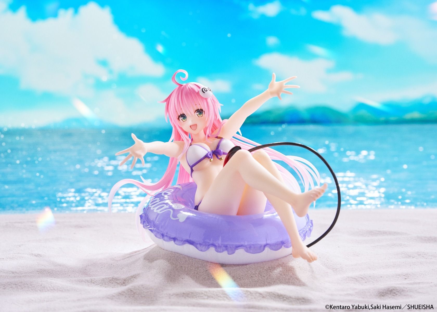 Figurine of a character with pink hair and a swimsuit on a beach with a blue sky.