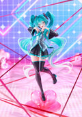 A stylized anime figurine of Hatsune Miku in a dynamic pose, standing on a translucent pink heart-shaped base against a neon pink and blue geometric background.