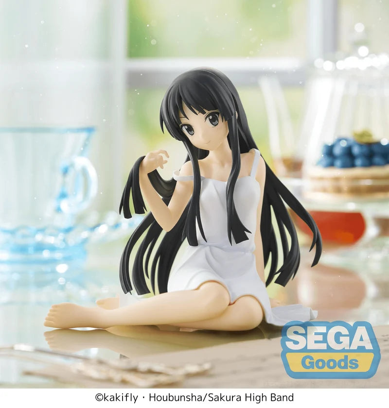 Figurine of a character with long black hair and a white dress sitting on a table, with 'SEGA Goods' branding.