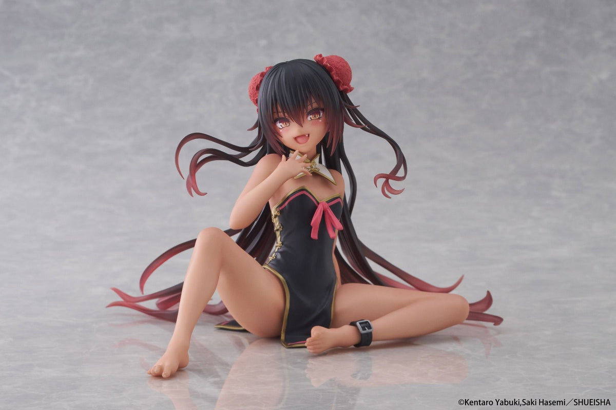 Anime character figurine in a black swimsuit with red hair accessories on a gray background