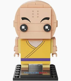 A small brick-built character figure with a bald head, black eyes, and a yellow robe with a purple stripe, standing on a black display base against a light gray background.