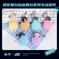 Colorful plush keychains on a checkered cloth with a keyboard in the background