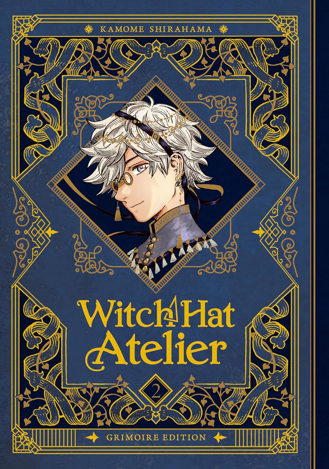 Front cover of the book 'Witch Hat Atelier' by Kamome Shirahama, featuring a dark navy blue background with ornate gold filigree borders and a central anime-style illustration of a character with white hair and a witch hat.